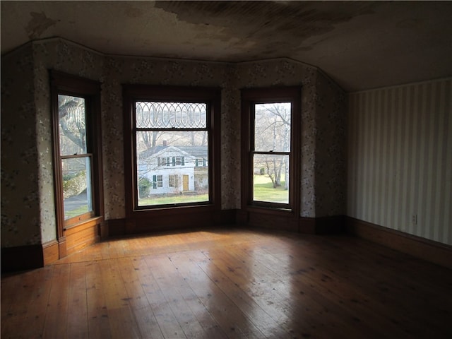 unfurnished room featuring light wood-type flooring and vaulted ceiling