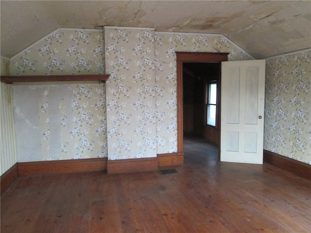 spare room with hardwood / wood-style flooring and lofted ceiling