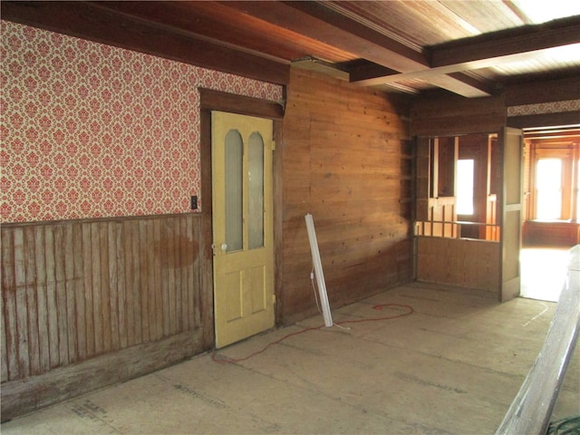 unfurnished room featuring beam ceiling