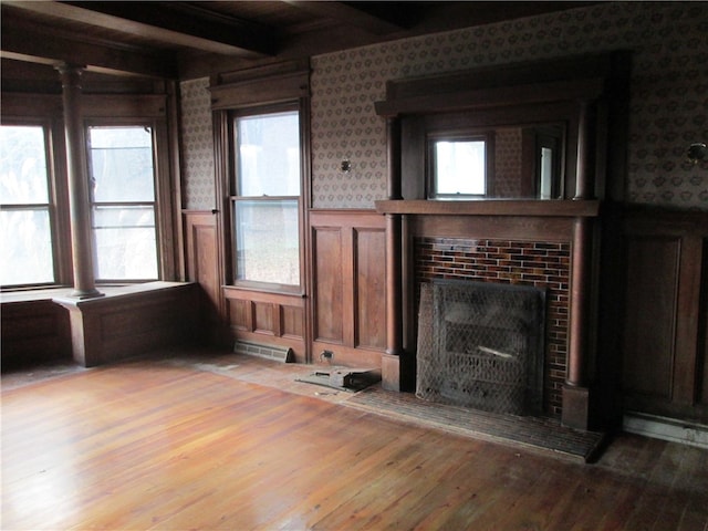 unfurnished living room with beam ceiling, light hardwood / wood-style flooring, and plenty of natural light