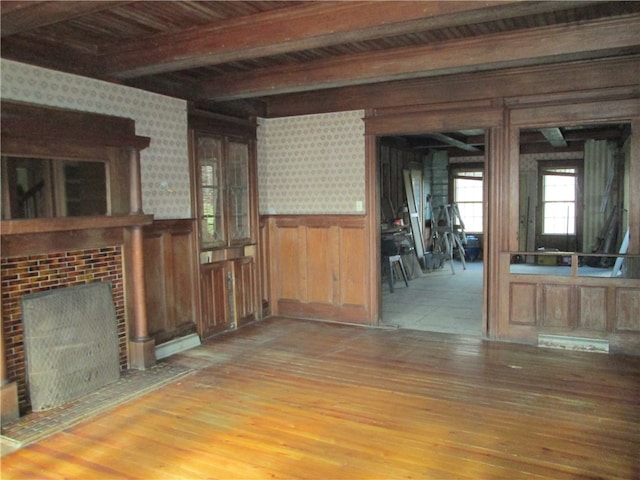 unfurnished living room featuring hardwood / wood-style floors and beam ceiling