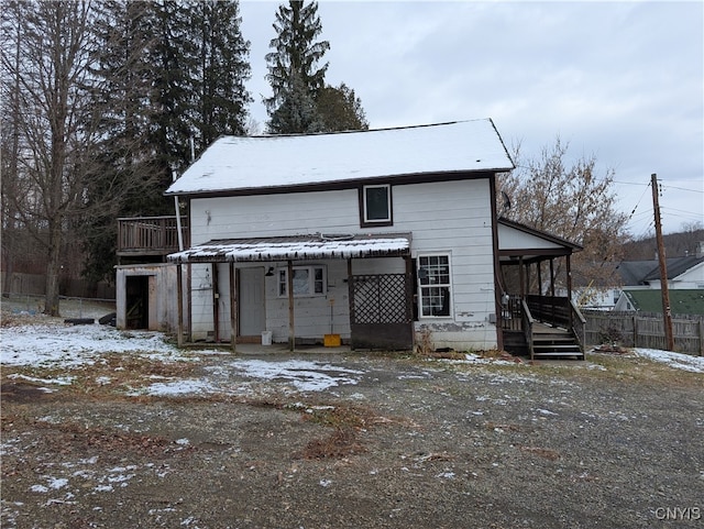 view of snow covered back of property