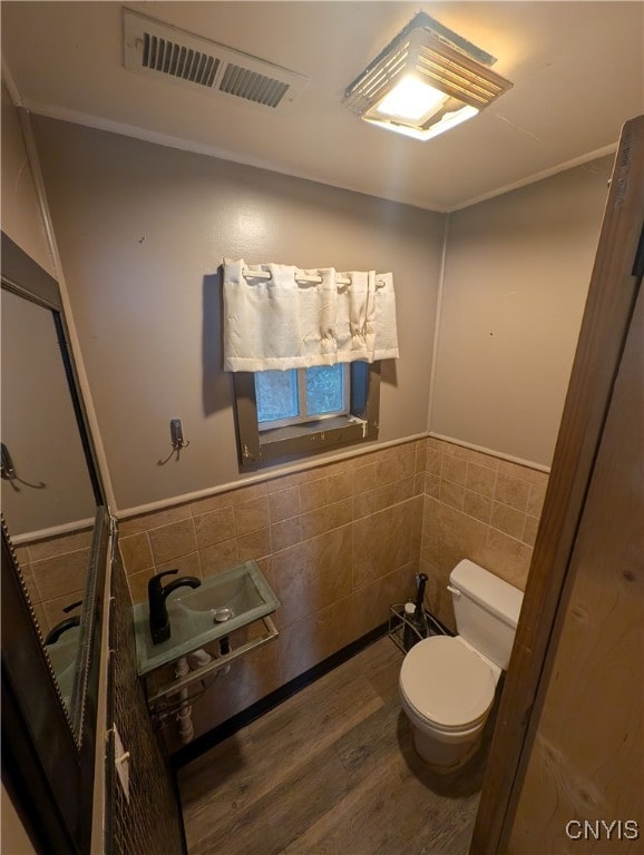 bathroom with sink, hardwood / wood-style floors, tile walls, and toilet