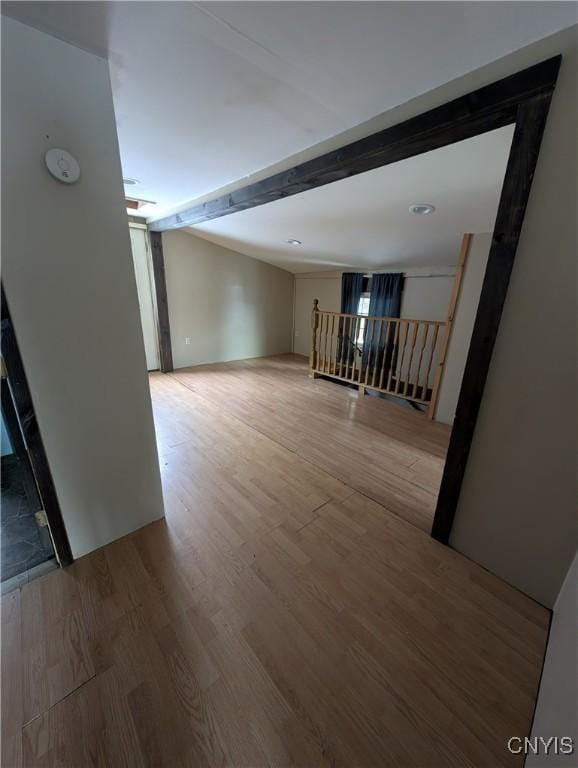 unfurnished room featuring beamed ceiling and wood-type flooring