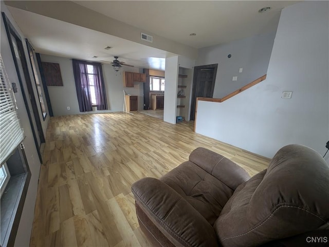 living room featuring ceiling fan and light hardwood / wood-style floors