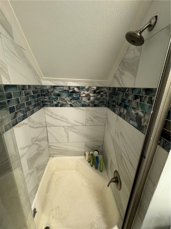 bathroom with a textured ceiling and tile walls