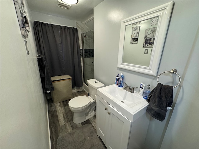 bathroom featuring curtained shower, hardwood / wood-style floors, vanity, and toilet