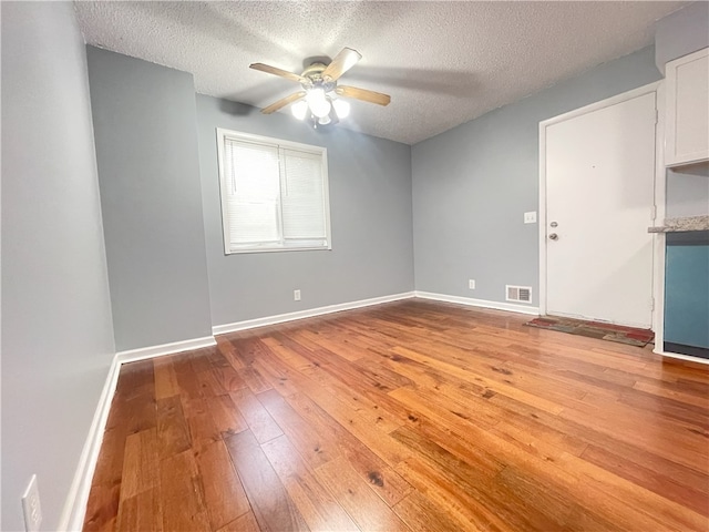 empty room with a textured ceiling, light hardwood / wood-style flooring, and ceiling fan