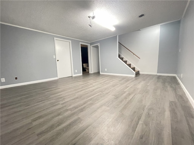 interior space with hardwood / wood-style flooring, ornamental molding, and a textured ceiling