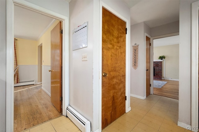 corridor with crown molding, light hardwood / wood-style flooring, and a baseboard heating unit