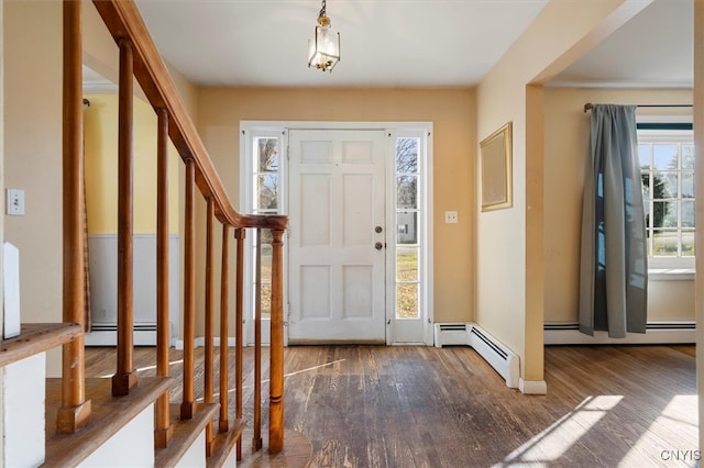 foyer entrance with a wealth of natural light, wood-type flooring, and a baseboard heating unit