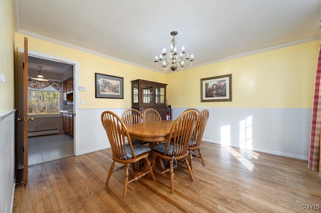 dining area featuring light hardwood / wood-style floors, an inviting chandelier, baseboard heating, and ornamental molding