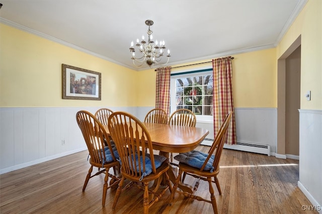 dining space with a chandelier, a baseboard heating unit, crown molding, and dark wood-type flooring