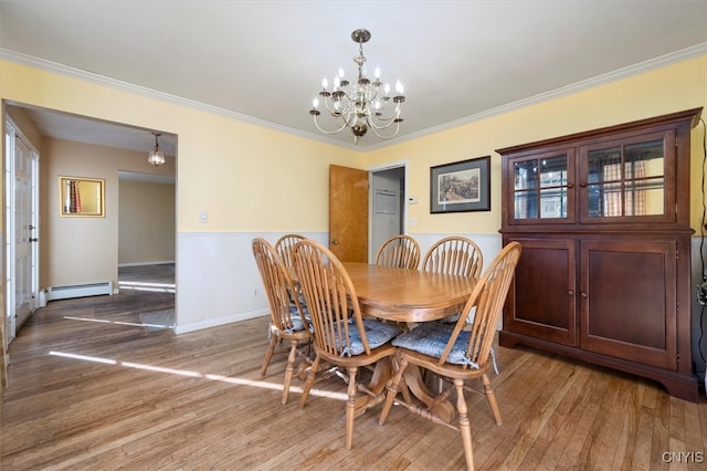 dining room with a chandelier, wood-type flooring, a baseboard radiator, and ornamental molding