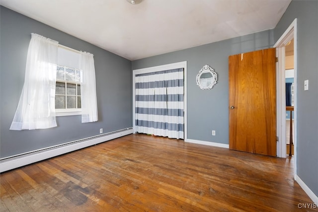 spare room featuring wood-type flooring and a baseboard radiator