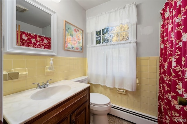 bathroom featuring vanity, toilet, tile walls, and a baseboard heating unit