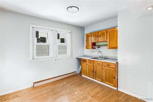 kitchen featuring light wood-type flooring, sink, and a baseboard heating unit