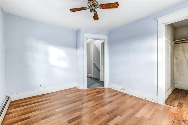 unfurnished bedroom with ceiling fan, a closet, light hardwood / wood-style floors, and a baseboard heating unit