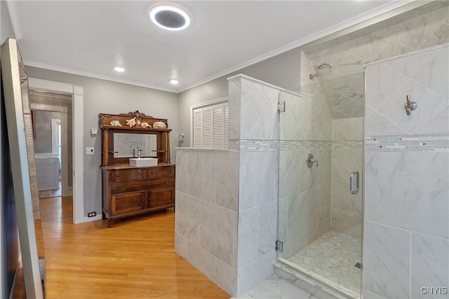 bathroom featuring hardwood / wood-style flooring, vanity, ornamental molding, and walk in shower