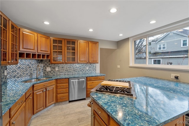 kitchen featuring backsplash, sink, stone countertops, light hardwood / wood-style flooring, and dishwasher