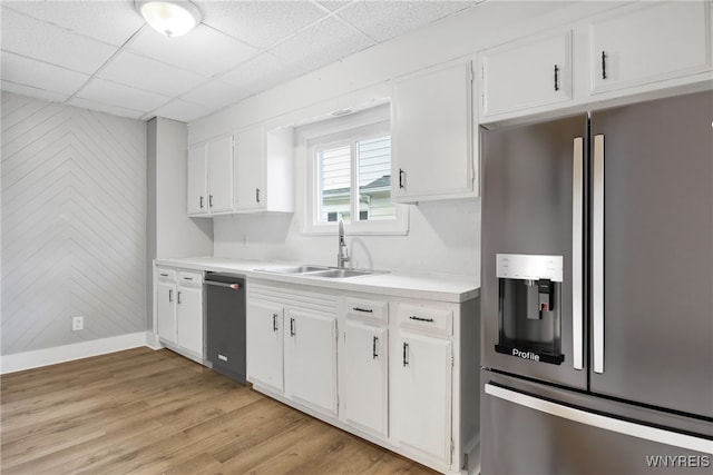 kitchen with a paneled ceiling, sink, stainless steel refrigerator with ice dispenser, light wood-type flooring, and white cabinetry