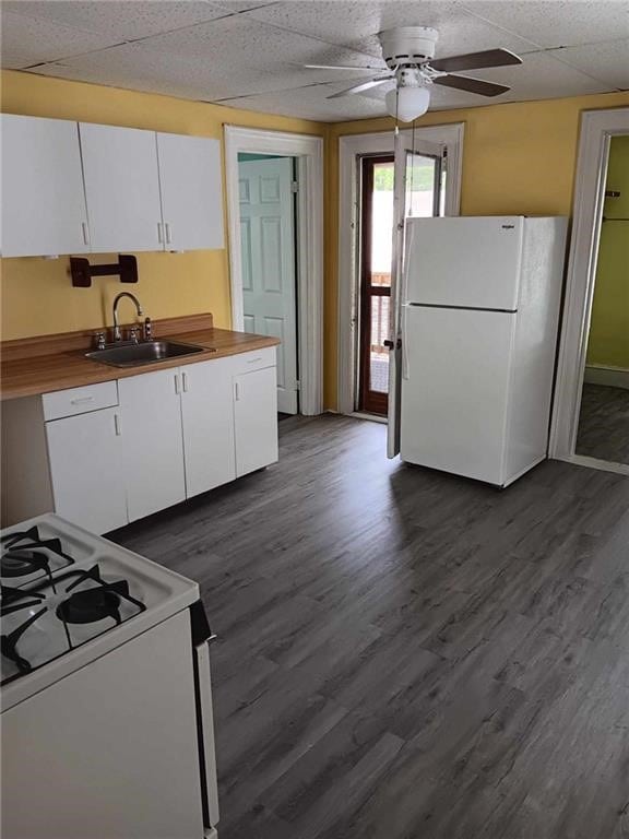 kitchen featuring sink, white cabinets, dark wood-type flooring, and white appliances