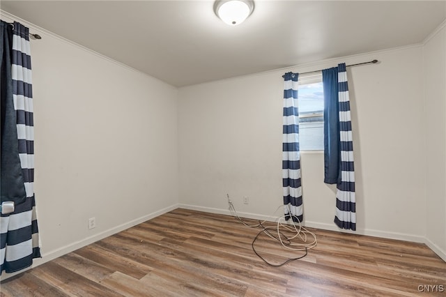 empty room with wood-type flooring and crown molding