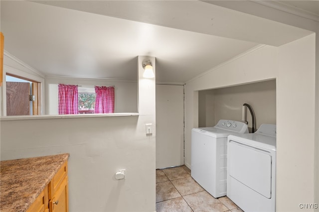 clothes washing area featuring separate washer and dryer, light tile patterned floors, and ornamental molding