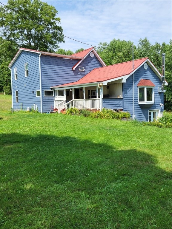 rear view of property featuring a porch and a yard