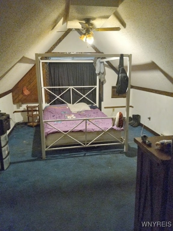 unfurnished bedroom with a textured ceiling, carpet floors, ceiling fan, and lofted ceiling