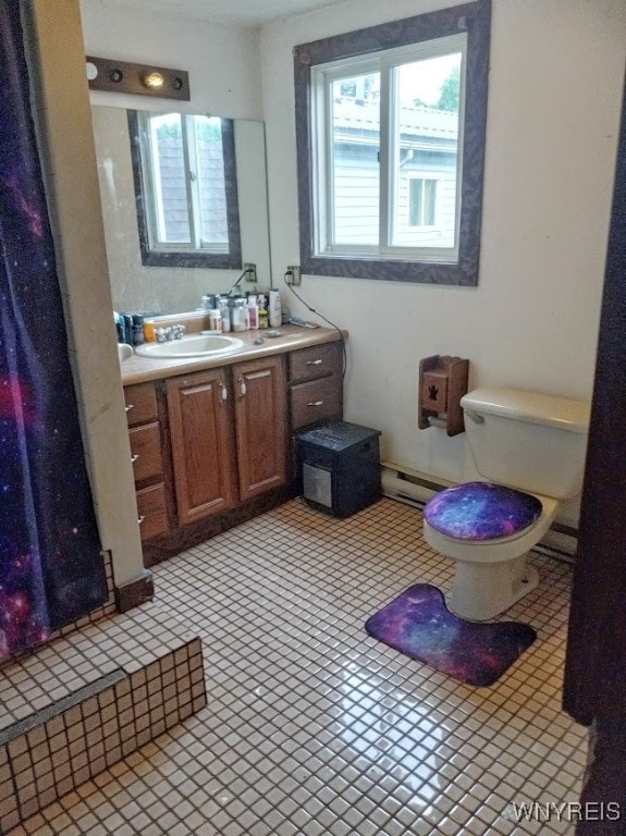 bathroom with vanity, toilet, and a baseboard heating unit