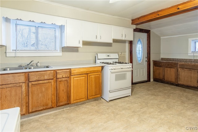 kitchen with white cabinets, white gas range oven, a healthy amount of sunlight, and sink