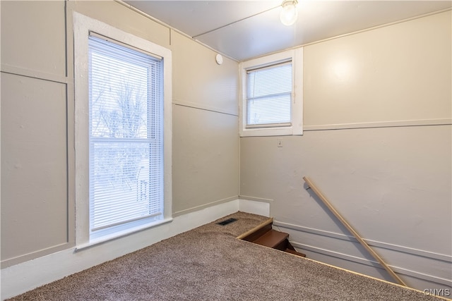 stairs with carpet and a healthy amount of sunlight