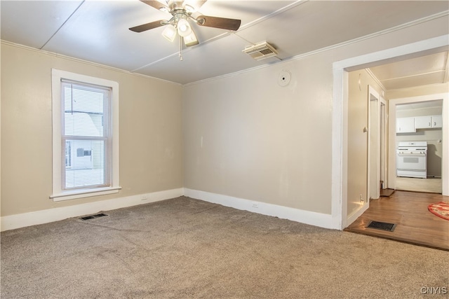 carpeted spare room featuring ceiling fan and crown molding