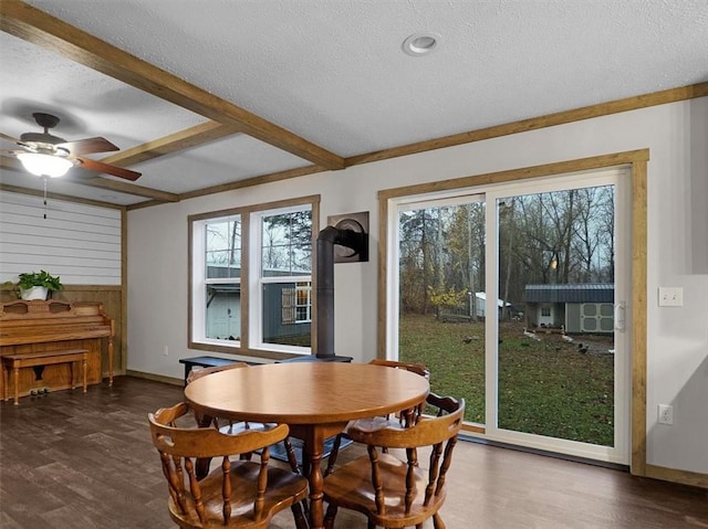 dining area featuring a textured ceiling, wooden walls, and a healthy amount of sunlight