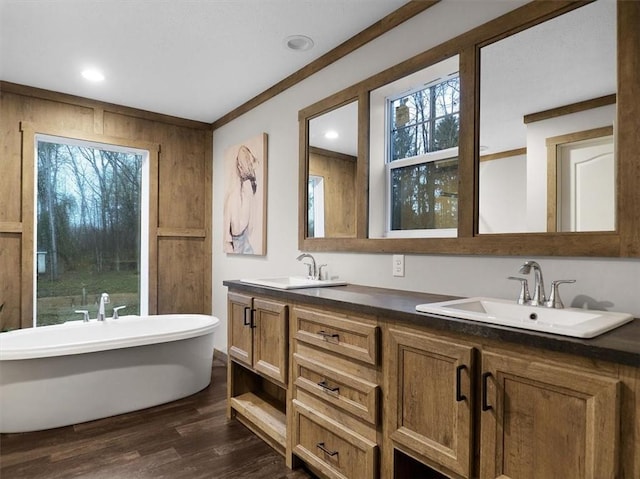 bathroom featuring crown molding, a bathtub, wood-type flooring, and vanity