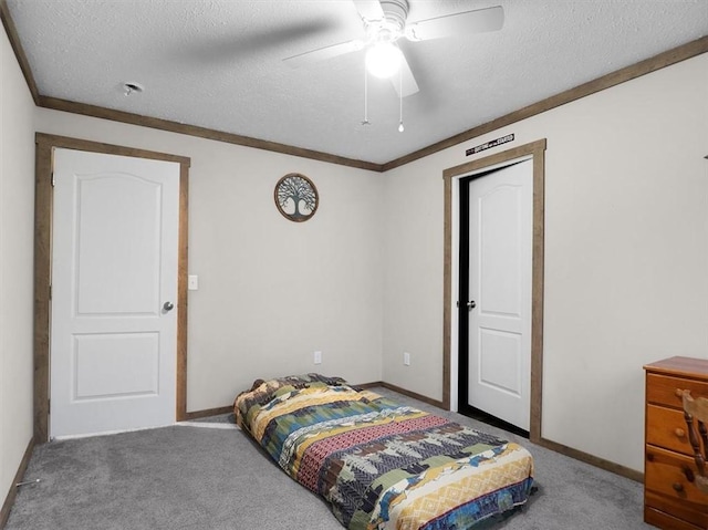 carpeted bedroom featuring a textured ceiling, ceiling fan, and crown molding