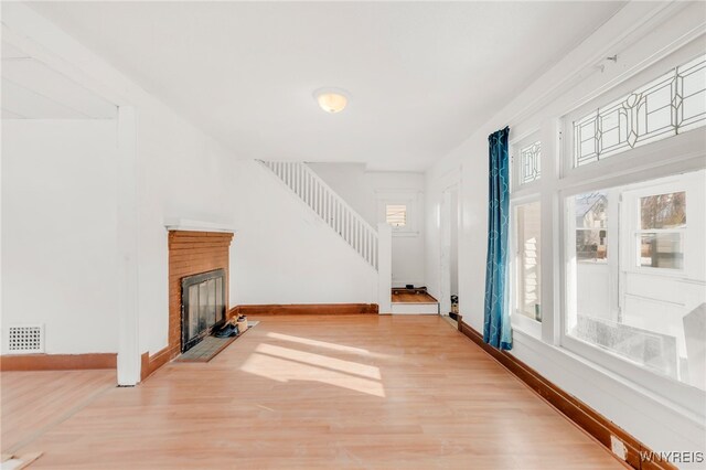 living room with hardwood / wood-style flooring and a brick fireplace