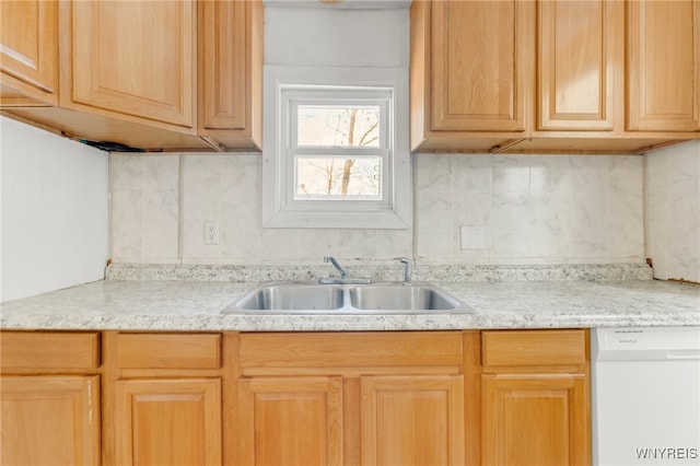 kitchen with dishwasher, decorative backsplash, sink, and light brown cabinetry