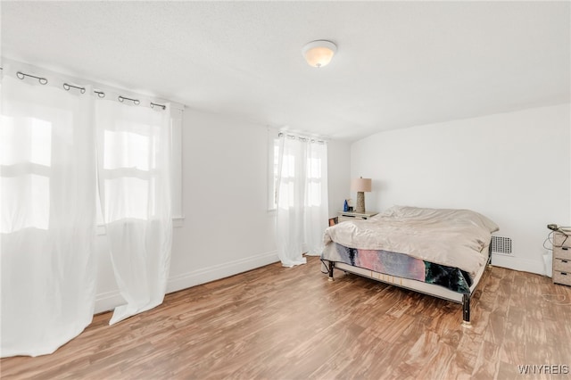 bedroom featuring hardwood / wood-style floors and lofted ceiling