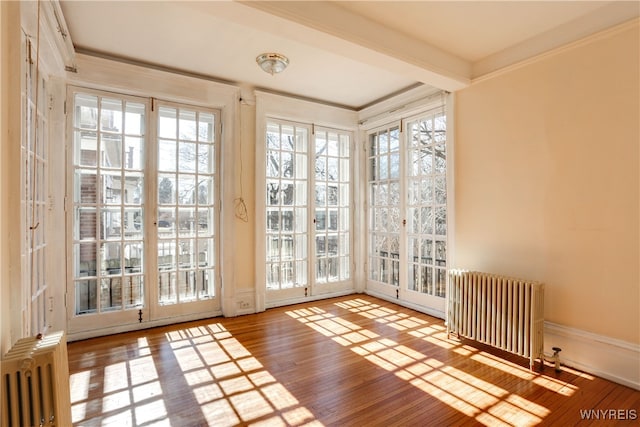 unfurnished sunroom with beam ceiling and radiator