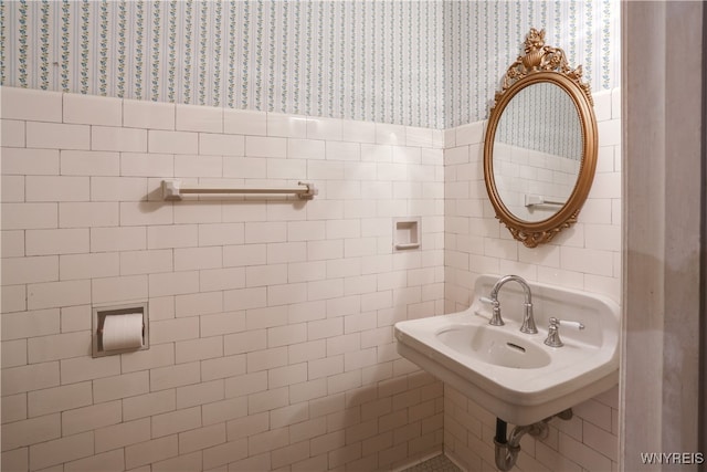 bathroom featuring sink and tile walls