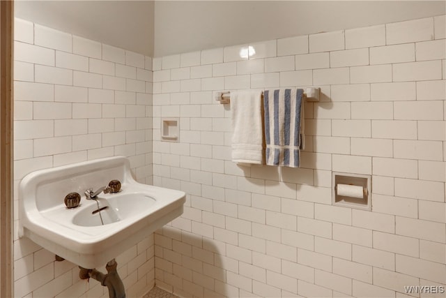 bathroom with tile walls and sink