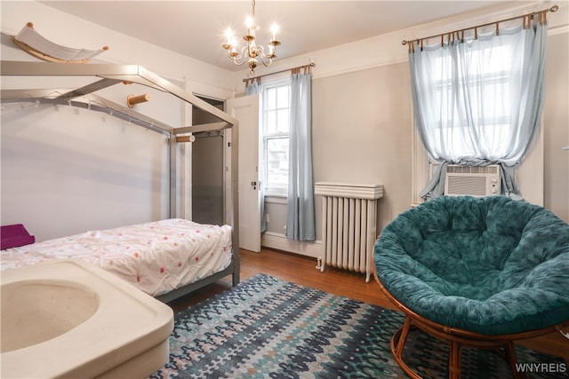 bedroom with a chandelier, wood-type flooring, radiator, and cooling unit