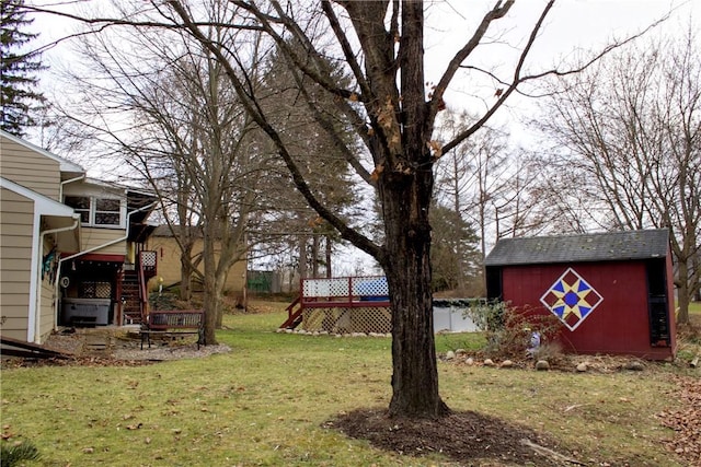 view of yard with stairway, a deck, a storage shed, and an outdoor structure