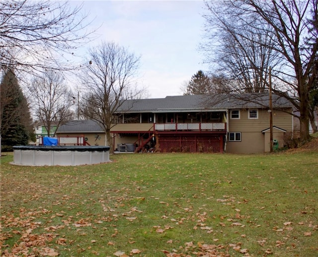 rear view of house featuring a yard and a pool side deck