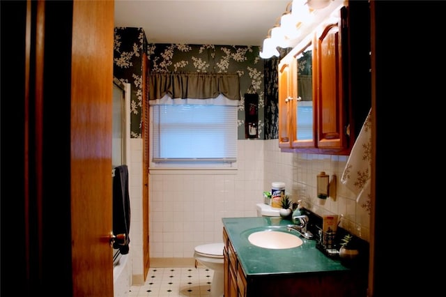 bathroom with tile patterned floors, vanity, toilet, and tile walls