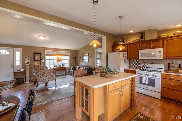 kitchen featuring light hardwood / wood-style flooring, pendant lighting, white appliances, decorative backsplash, and a kitchen island