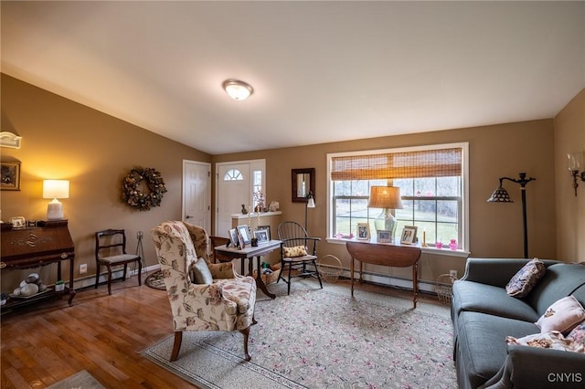 living room with wood-type flooring, vaulted ceiling, and baseboard heating