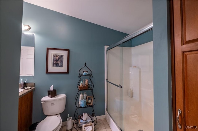 bathroom with tile patterned floors, vanity, toilet, and a shower with shower door